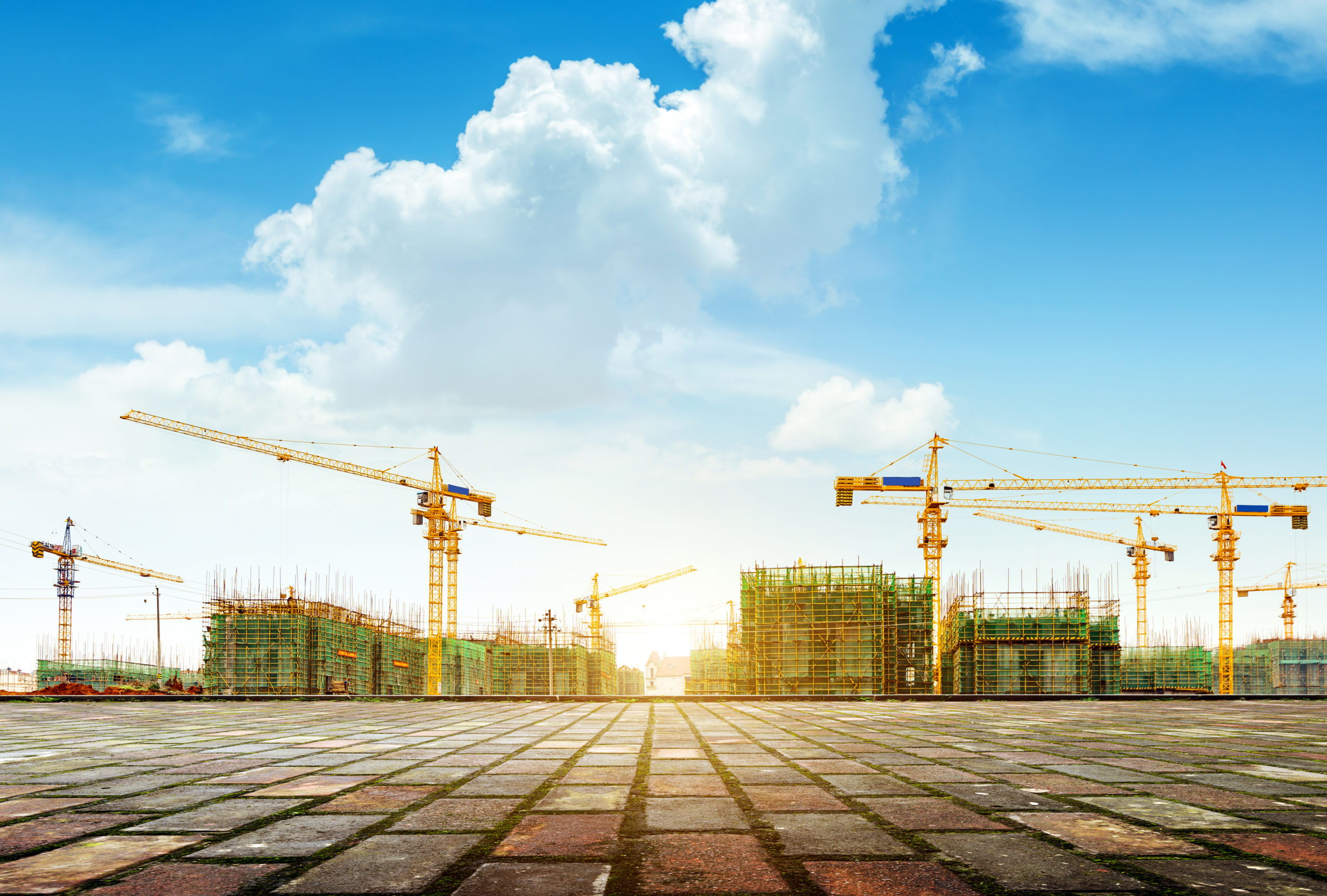 Crane and building construction site against blue sky